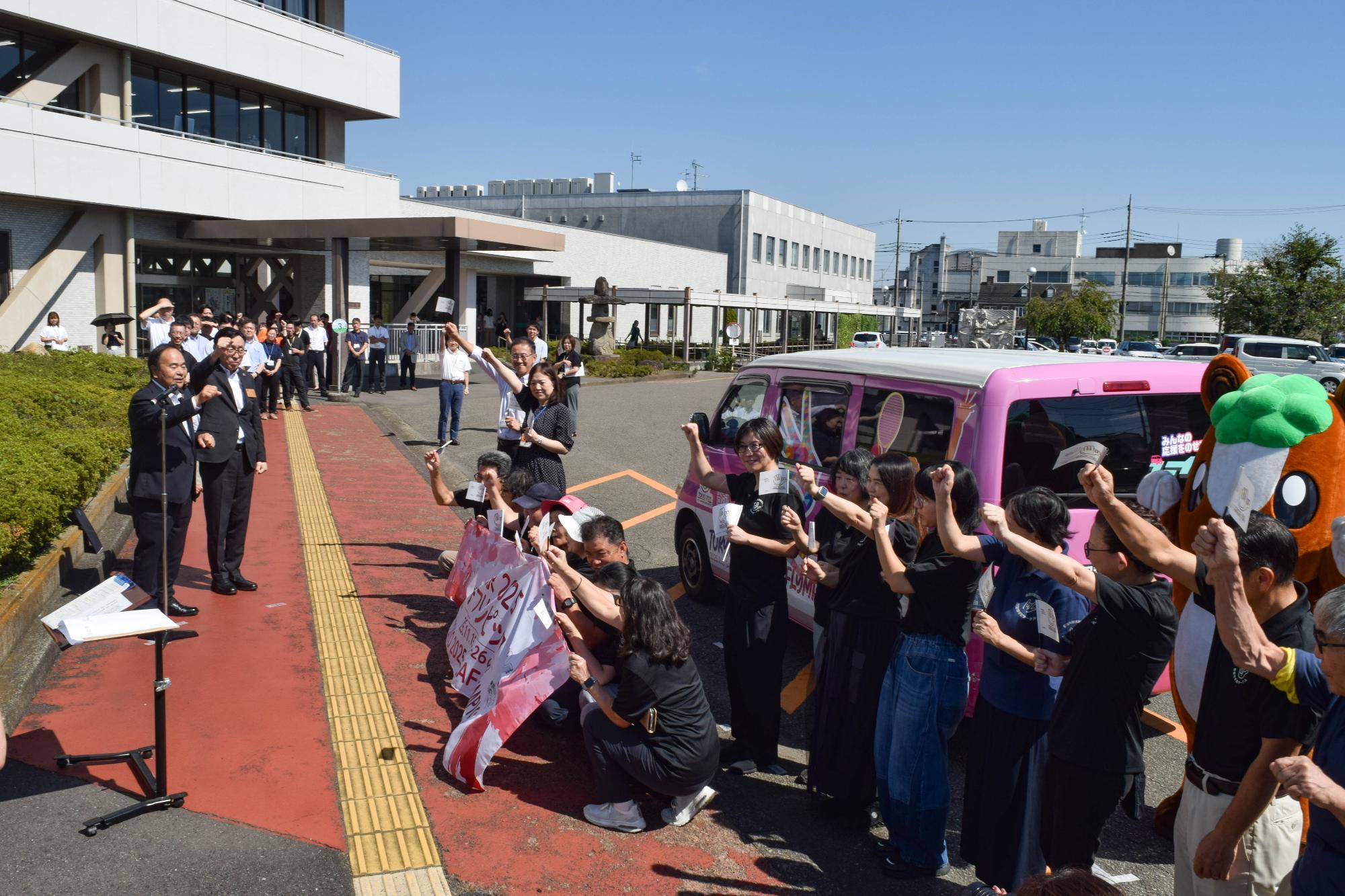 市長の掛け声で参加者が拳を突き上げている様子