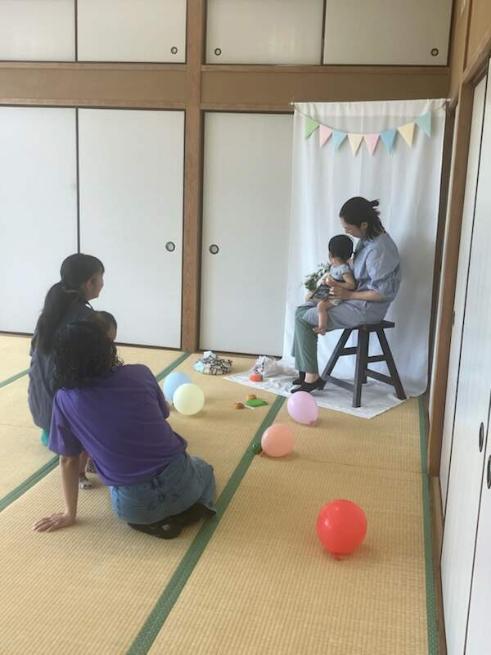 和室に写真撮影用の飾りをしてそこで親子が写真撮影をしている様子