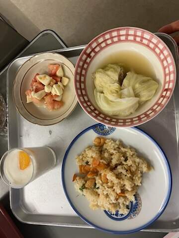 作り終えた料理、エビピラフと豆腐とお麩のロールキャベツ、角切りカプレーゼ、ミカンラッシーが盛り付けられている様子