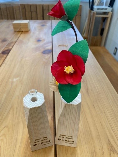 西川材で作られた花瓶と椿の花のブレア市への記念品の写真