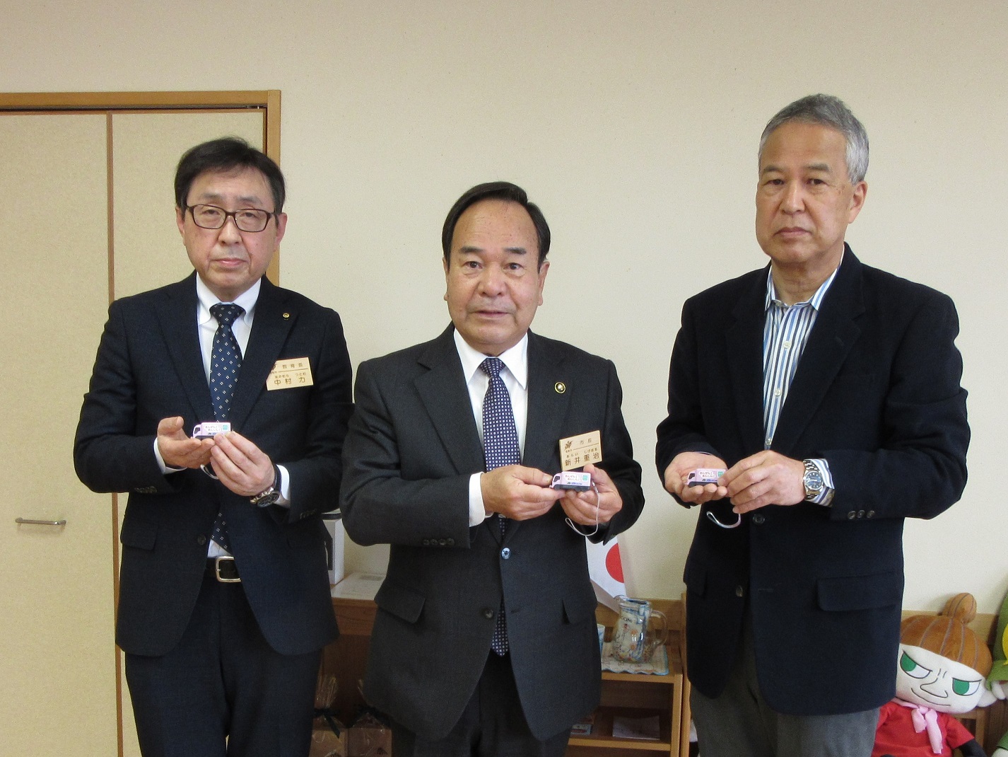 埼玉県トラック協会の方と頂いた防犯ブザーを手にしている市長の写真