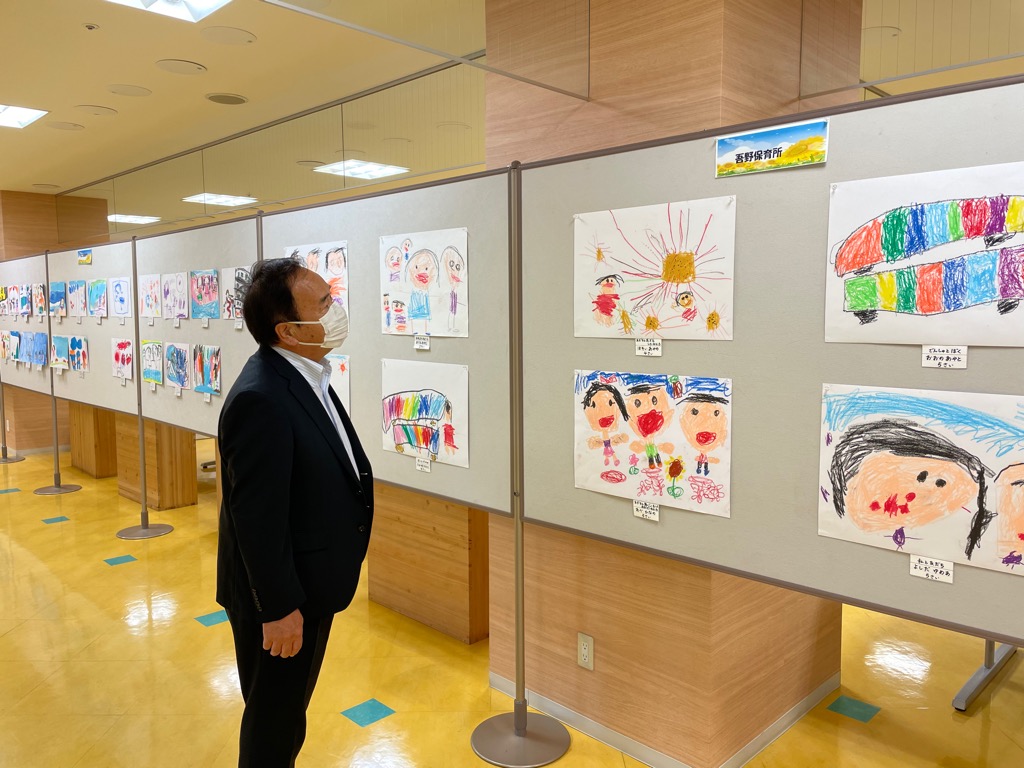 展示された子どもたちの絵画を鑑賞する市長の写真