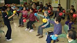 健康体操クラブの皆さんが椅子に座りながらボールを使って体操している様子の写真