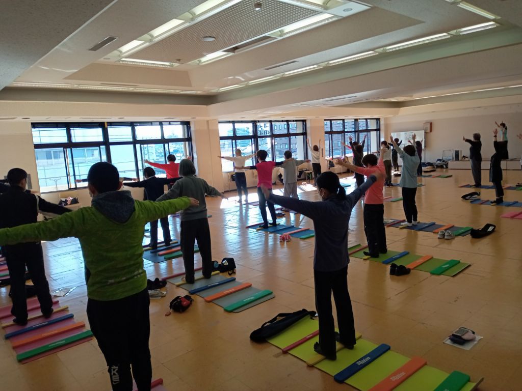参加者がバランススティックに横向きに乗ってエクササイズしています。
