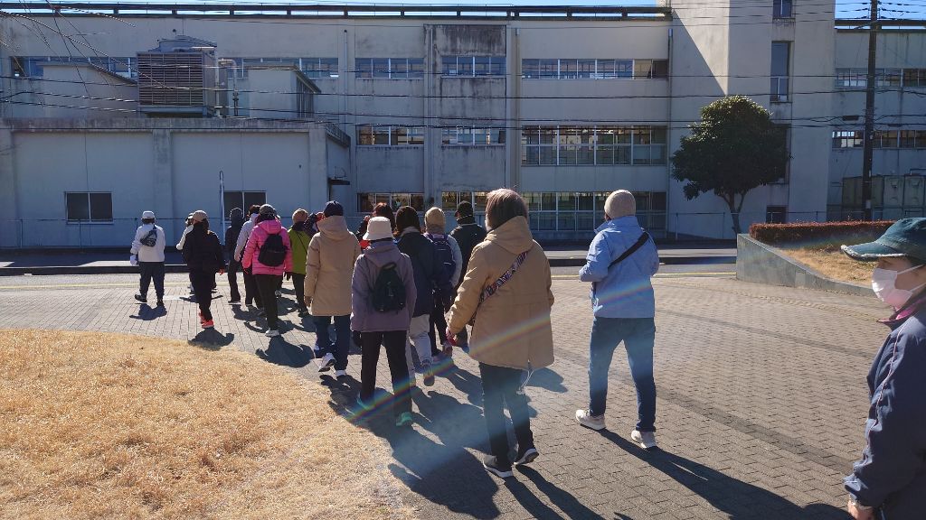 令和6年度に開催された講座の様子です。20人ほどの参加者が図書館から出発したところです。