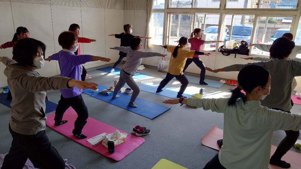 令和6年度に開催された講座の様子です。参加者が両手を横に広げ顔を横に向けたポーズをとっています。