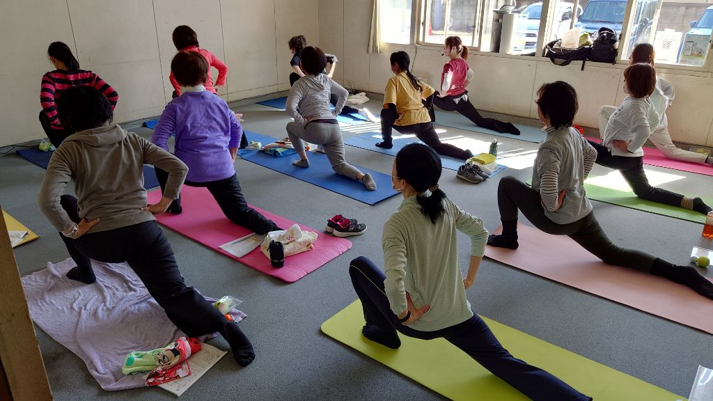 令和6年度に開催された講座の様子です。立ち膝の姿勢から片足を前に立て反対の脚を後ろに引き、股関節を伸ばすストレッチをしています。