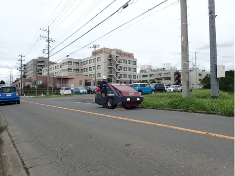 株式会社齋藤土木建材の方が、道路清掃専用車(アルマジロ)に乗り道路を清掃している様子の写真