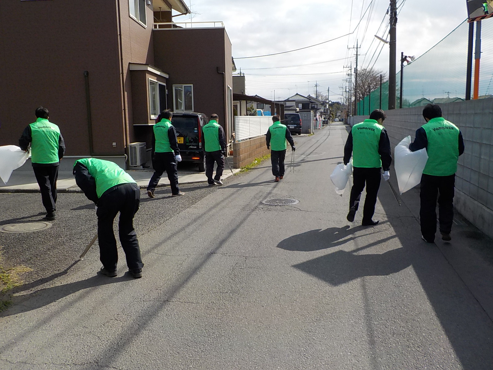 株式会社ヤマスズの方々が、道路で清掃活動を行っている様子の写真