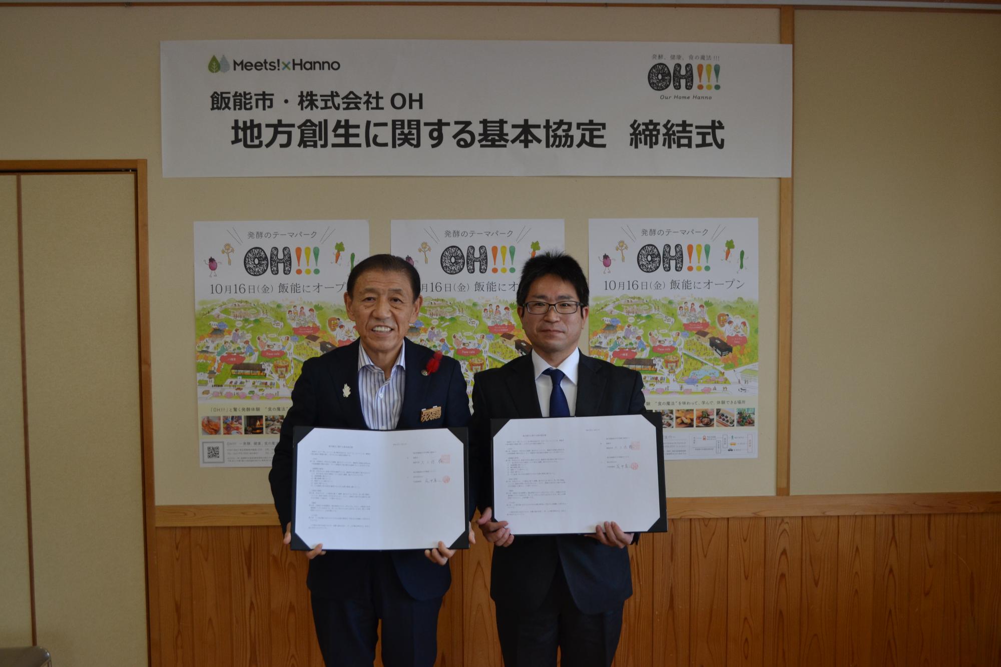 締結式で連携協定書を手に持って並んでいる市長と株式会社OH取代表締役社長の写真