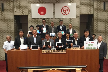 タブレットを手に持った富山県砺波市議の方々との集合写真