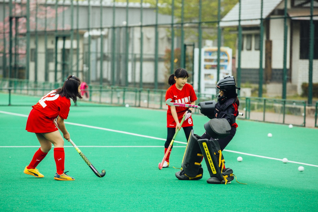 女子選手がゴールキーパーを相手にシュート練習を行なっている様子の写真