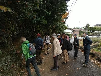 飯能を知ろウオークの参加者が、天覧山の地質についての解説を現場で熱心に聞いている写真