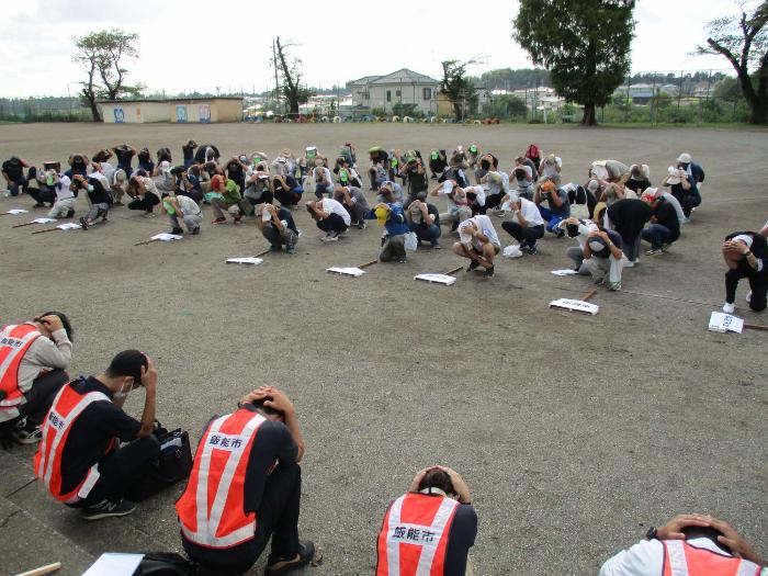 地震訓練にて校庭でシェイプアップ訓練をする参加者の写真