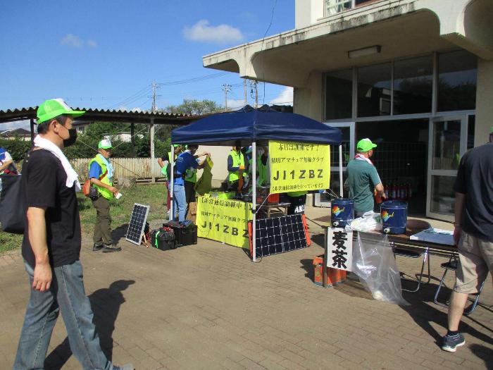 地震訓練にて校舎西側昇降口前で連絡訓練をする参加者(精明アマチュア無線クラブ)の写真