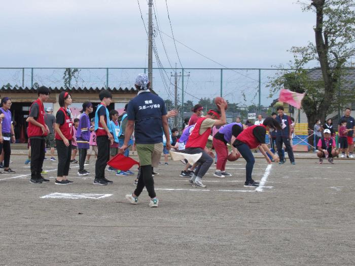 地区体育祭にてボール送り競走をする参加者の写真