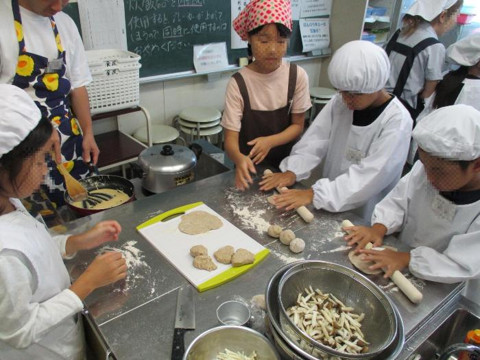 捏ねたチャパティの生地を同じ大きさに切り分け、麺棒で薄く延ばす参加者の写真