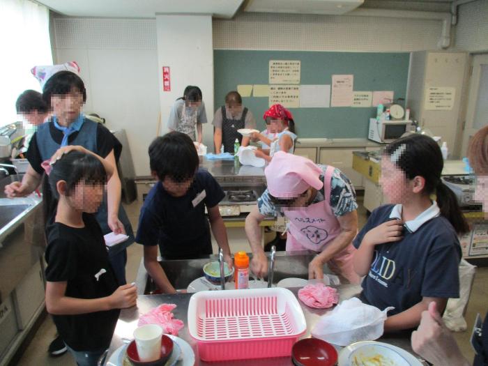調理等で使用した調理器具等を参加者全員で片付けている写真