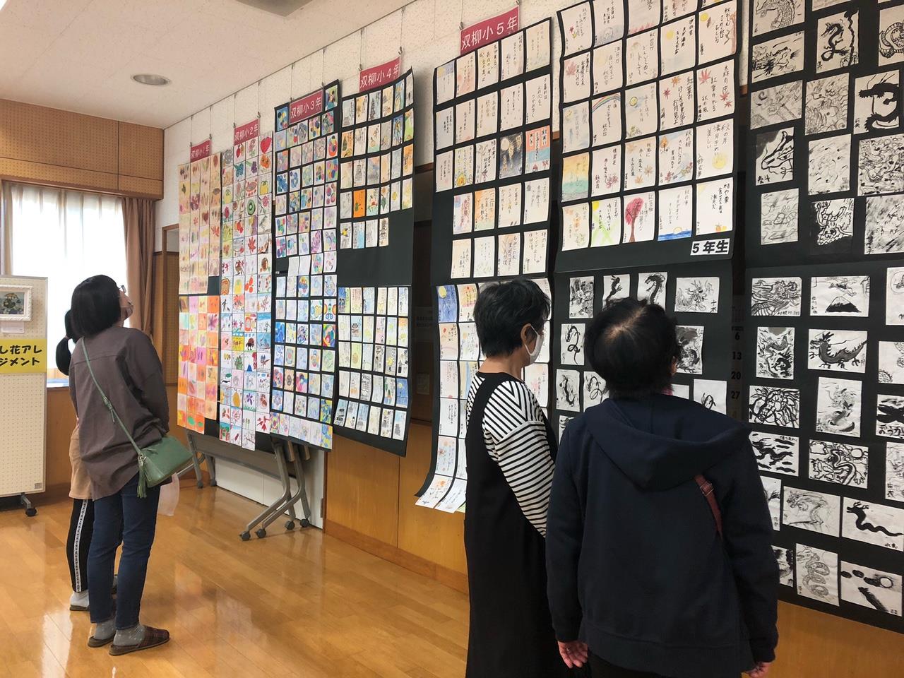 文化祭に訪れた方々が、展示されている絵画などの作品を見ている様子の写真