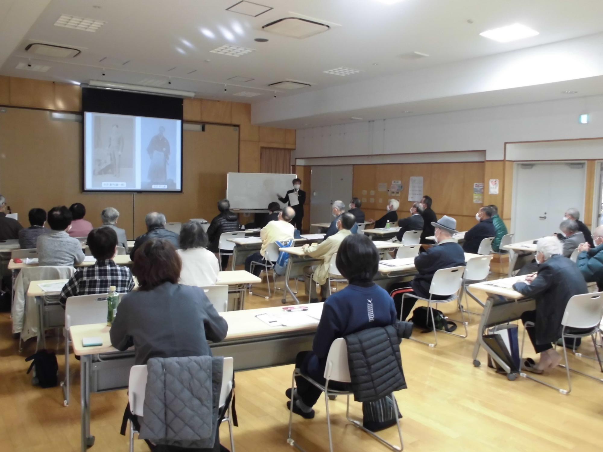 参加者たちが映像を見ながら飯能戦争について学んでいる様子の写真