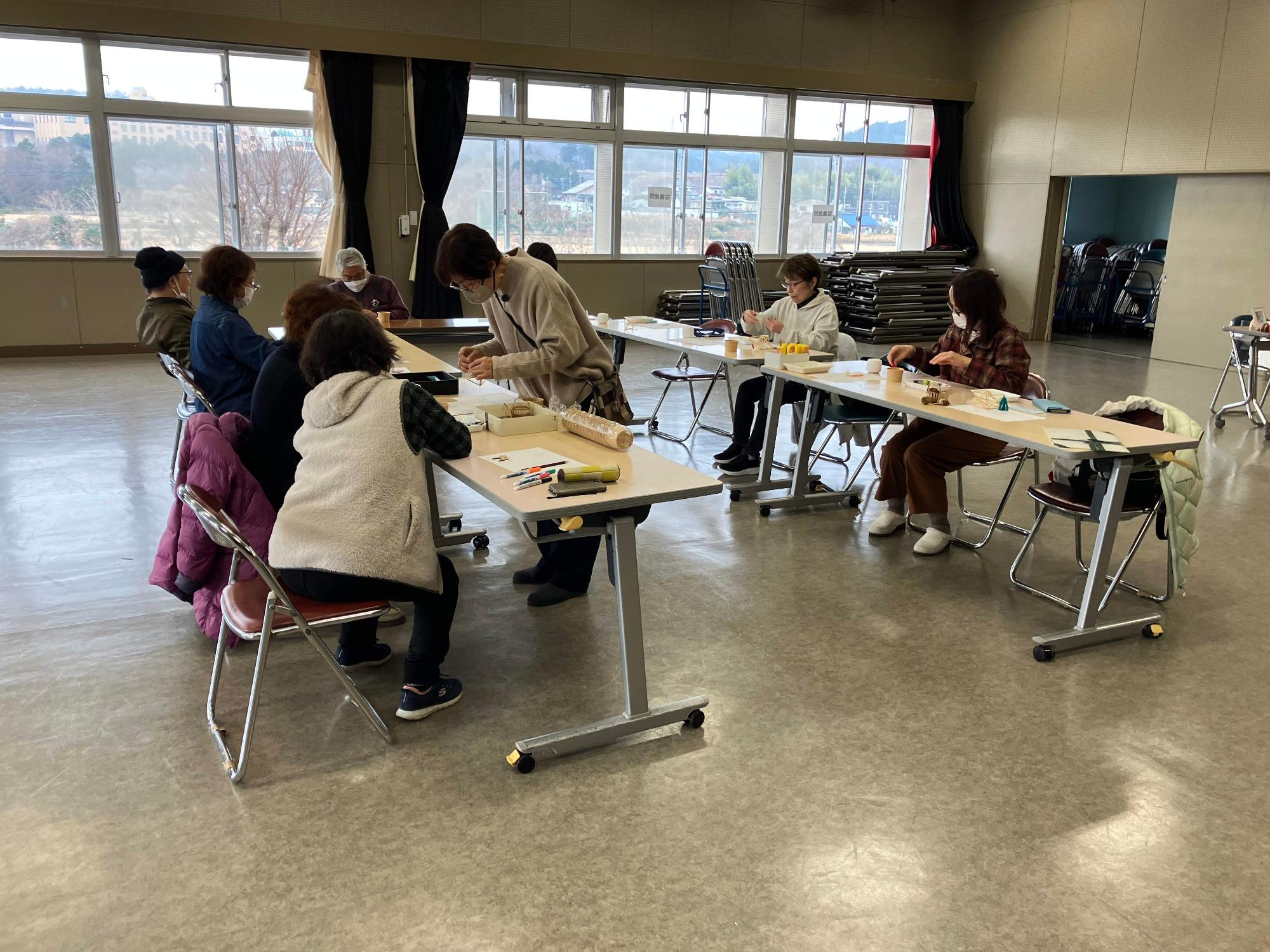 参加者12名の皆さんがヒンメリ作りの藁に糸通しに取り組んでいる様子