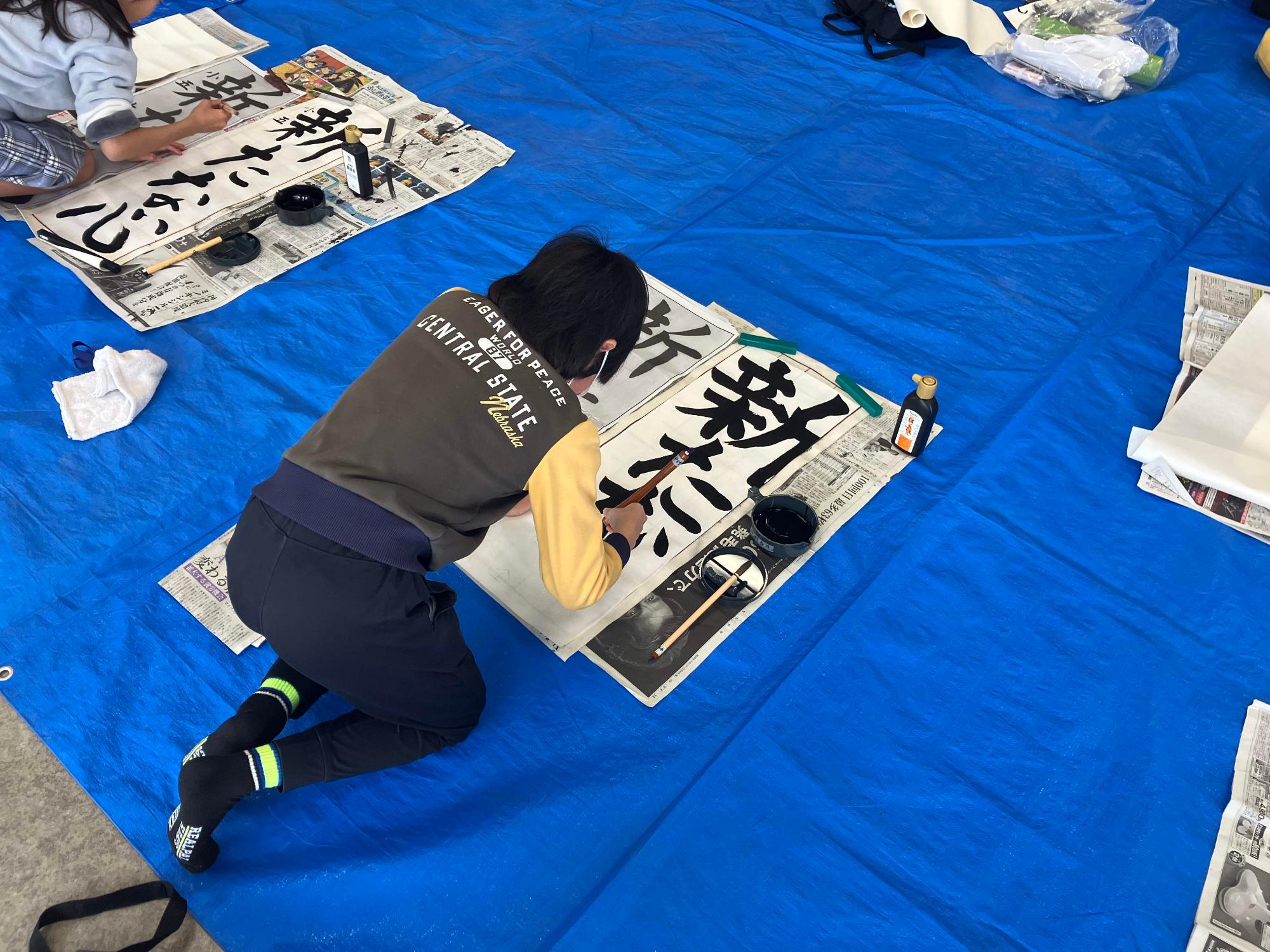 半紙に向かい集中して書いている男の子の様子