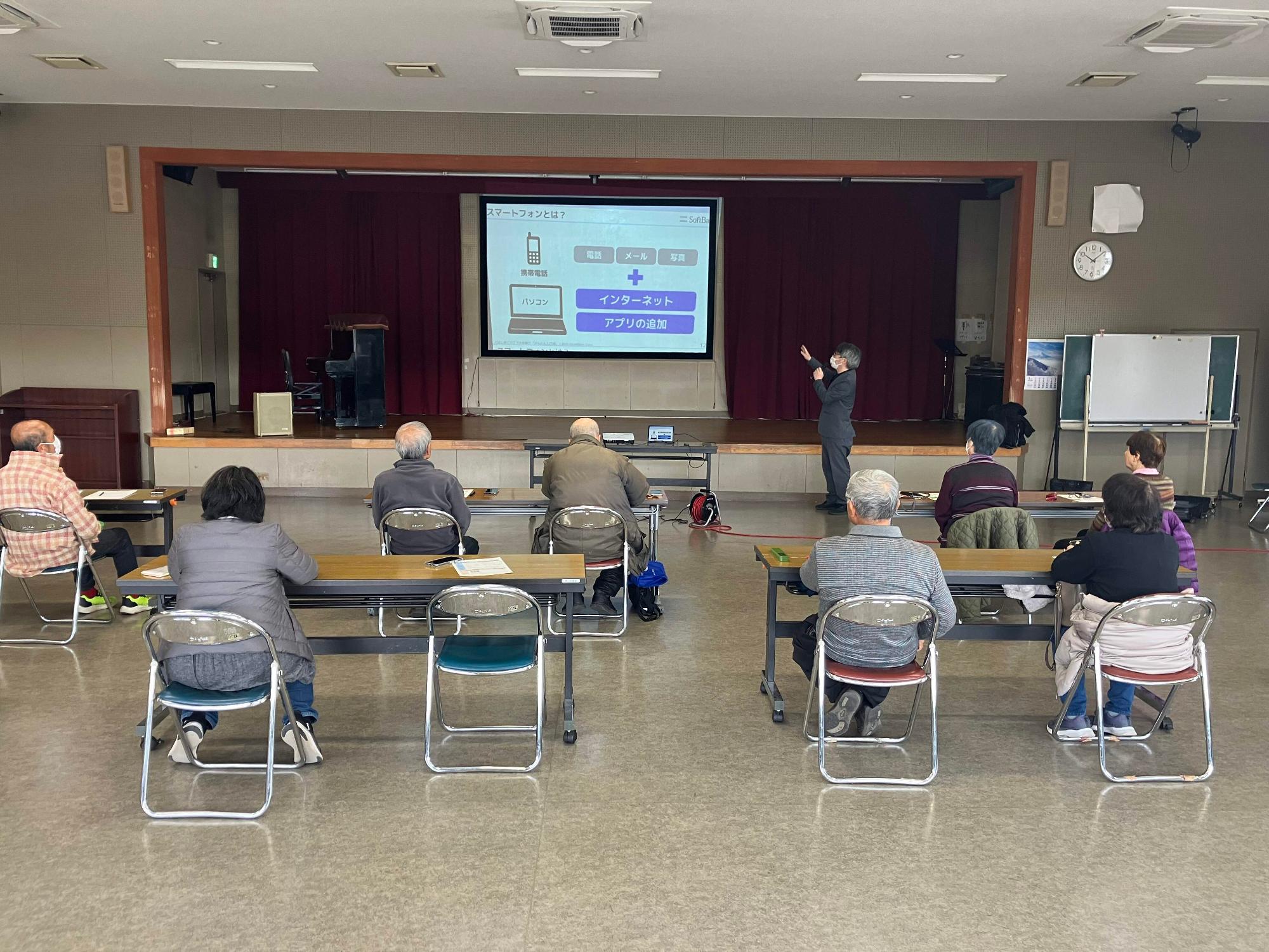 参加者の皆さんが、スクリーンに映る資料で説明を聞く様子