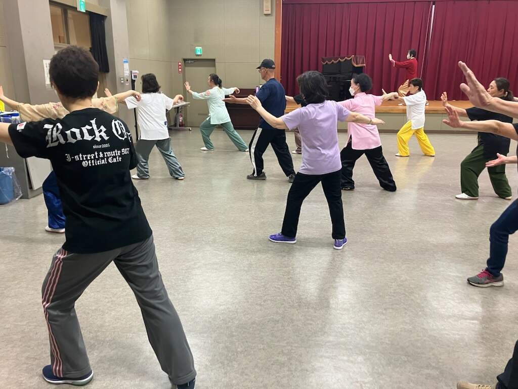 片足を前に出し少し膝を曲げ、同じ方の手を肩の高さに上げ手のひらを前に突き出し、もう片方の手は真横に肩の高さまで上げたポーズをしているみなさん