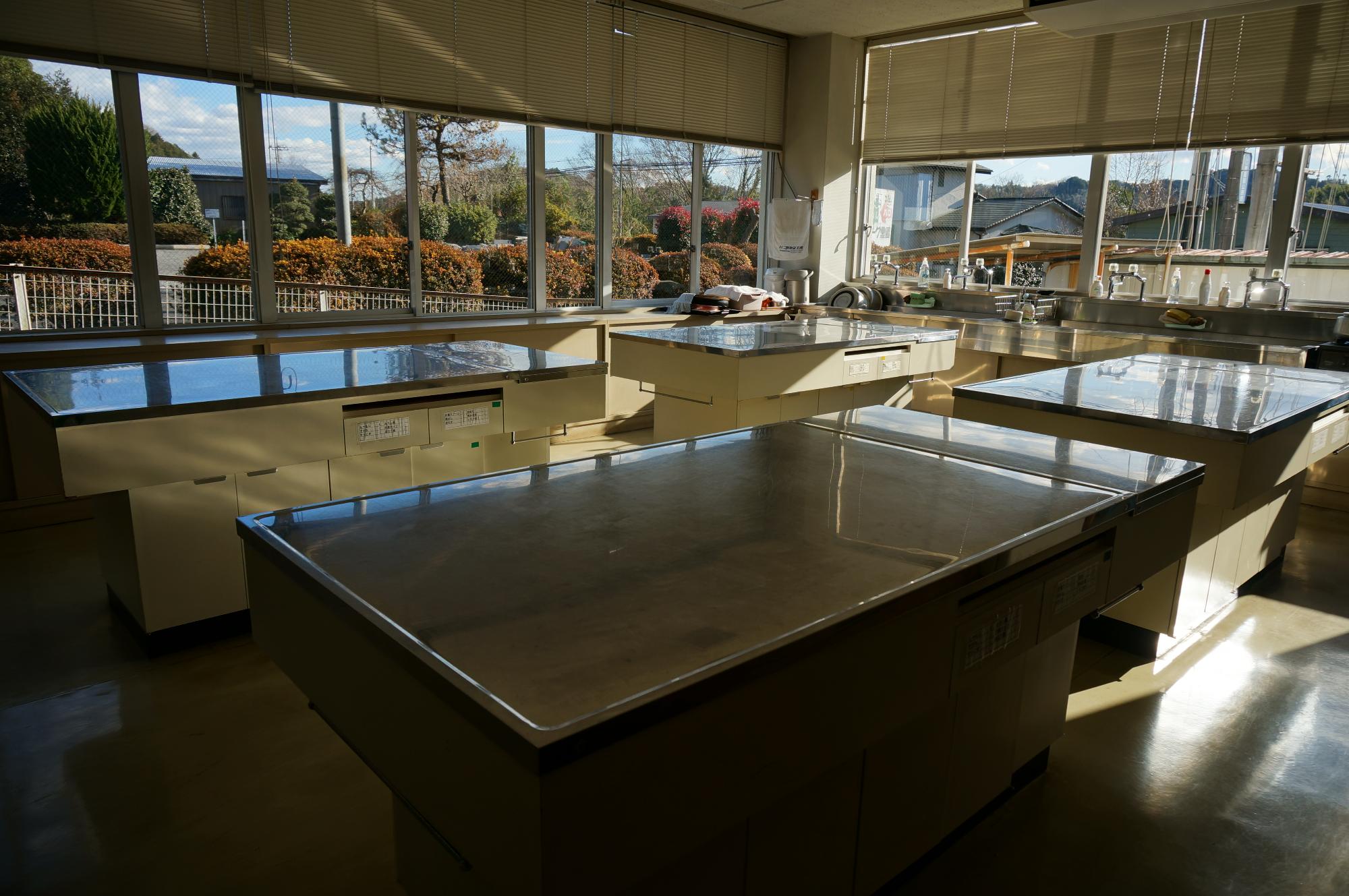 広々とした室内に4台の調理台が設置されている、調理室の写真