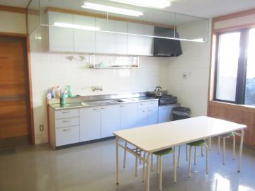 調理台とテーブルが一つずつ設置されている、調理室の写真