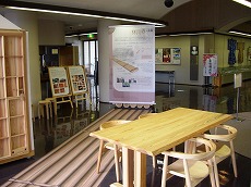筏の長さを表しているシートと西川材製のテーブルと椅子の写真