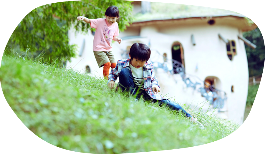 男の子と女の子が公園の芝生で遊んでいる様子の写真