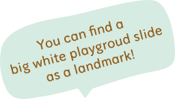 You can find a big white playground slide as a landmark!